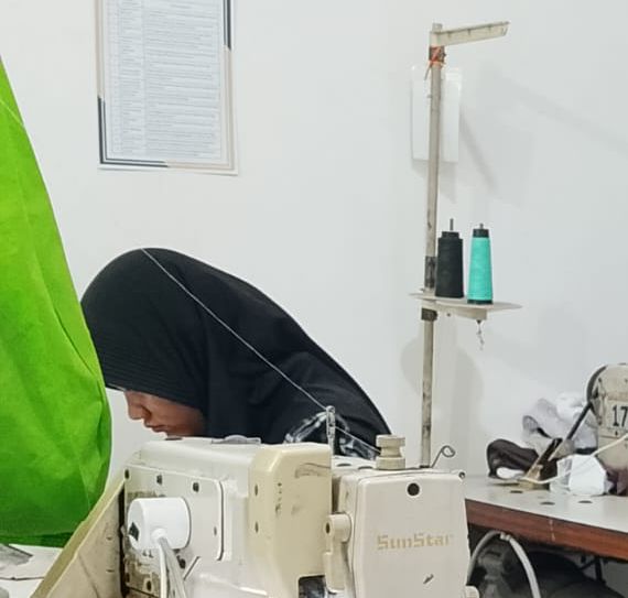 Peserta pelatihan berjilbab sedang menjahit di mesin jahit industri SunStar di kelas LPK Cipta Manpower Tangguh