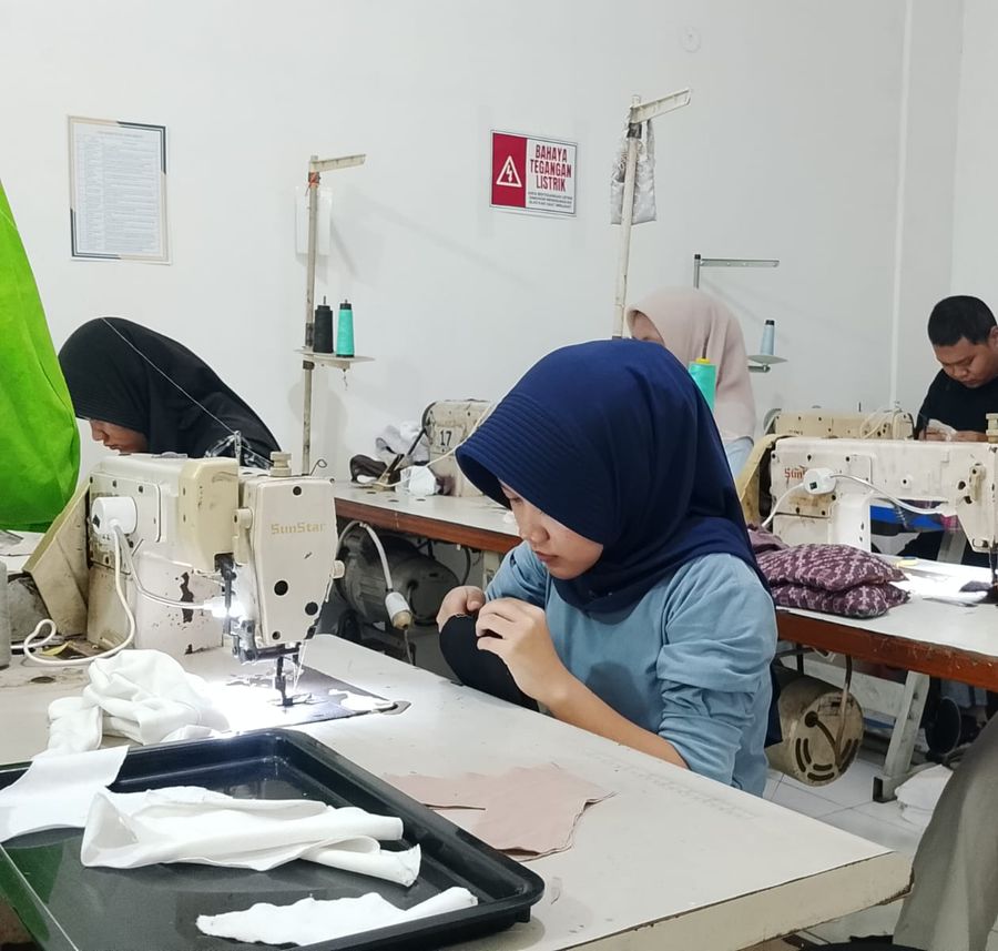 Peserta pelatihan berjilbab sedang menjahit di mesin jahit industri di kelas LPK Cipta Manpower Tangguh